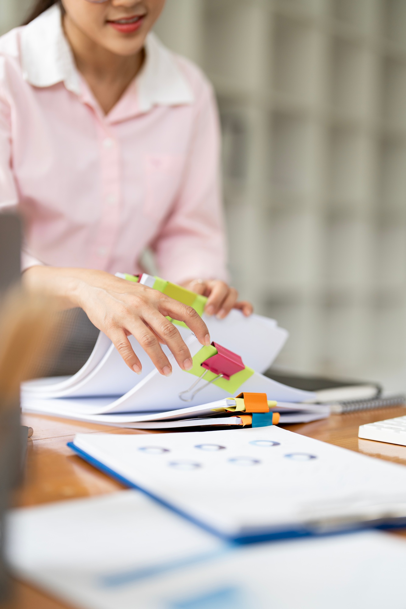 woman hands working in Stacks of paper files for checking unfinished document achieves